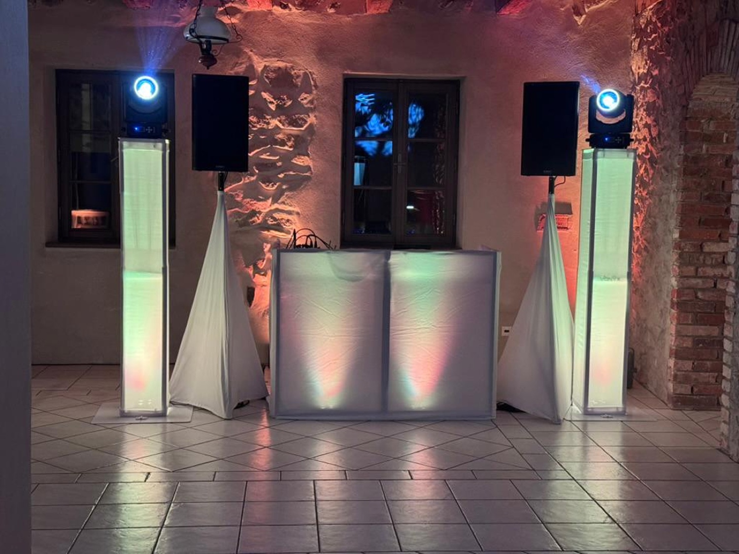 DJ pult so svetelnými totemami v kamennej sále